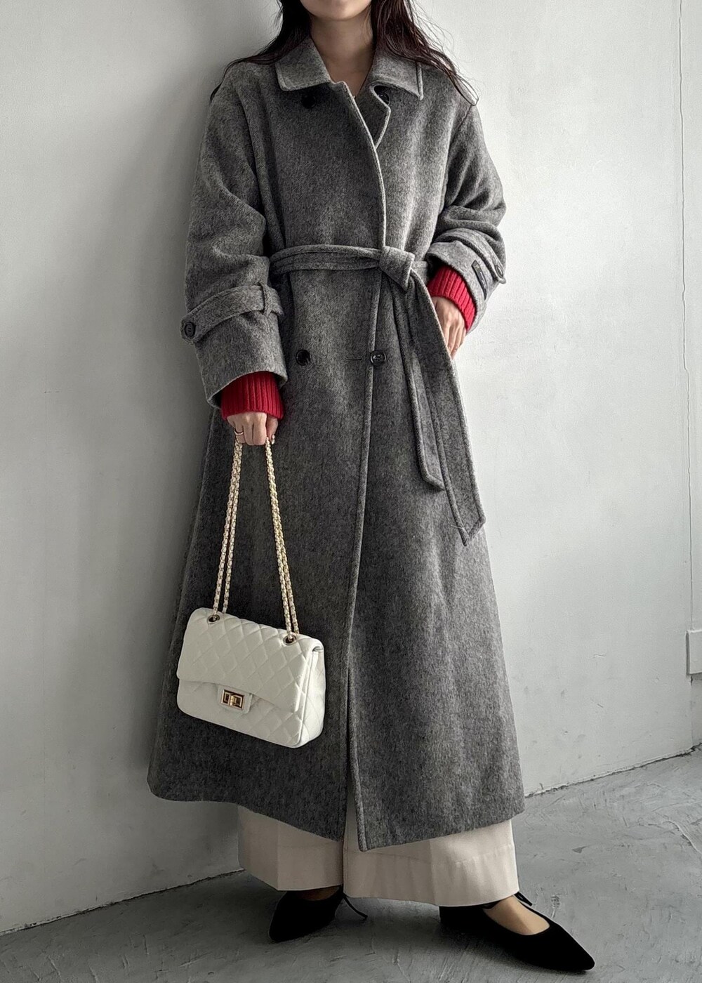 ホワイト系のショルダーバッグ、グレー系のステンカラーコート、ベージュ系のその他パンツを着用したレディースの秋コーディネートの2枚目の写真
