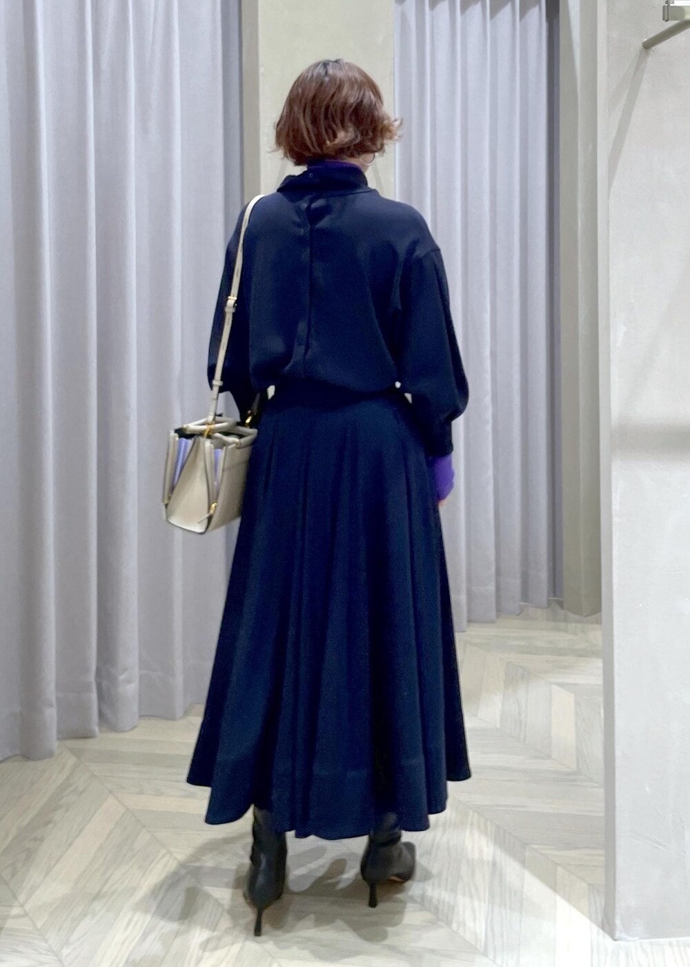 ブラック系のブーツ、ベージュ系のハンドバッグ、ブルー系のスカートを着用したレディースの冬コーディネートの5枚目の写真