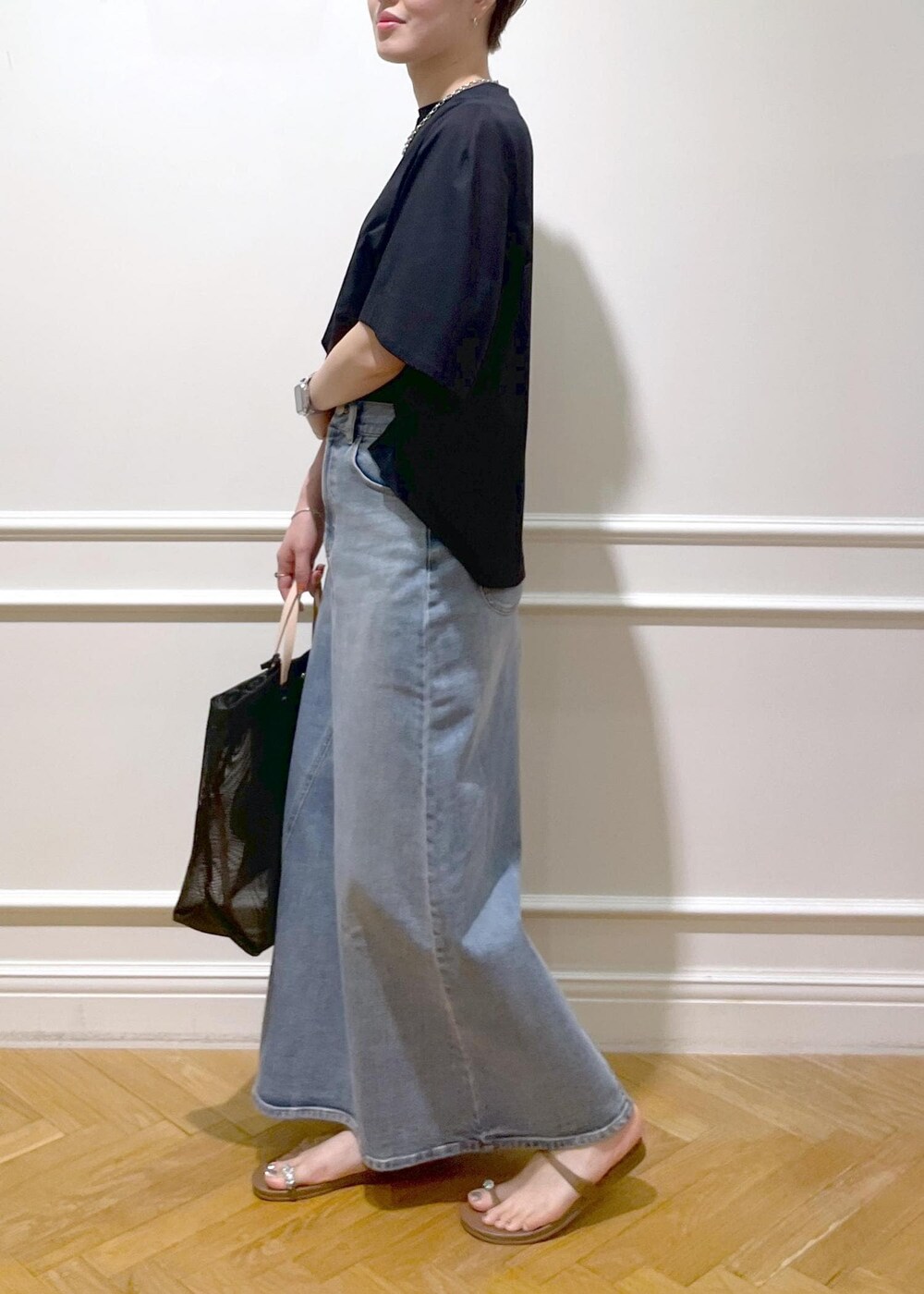 ブラック系のトートバッグ、ベージュ系のサンダル、ブラック系のTシャツ/カットソーを着用したレディースの夏コーディネートの2枚目の写真