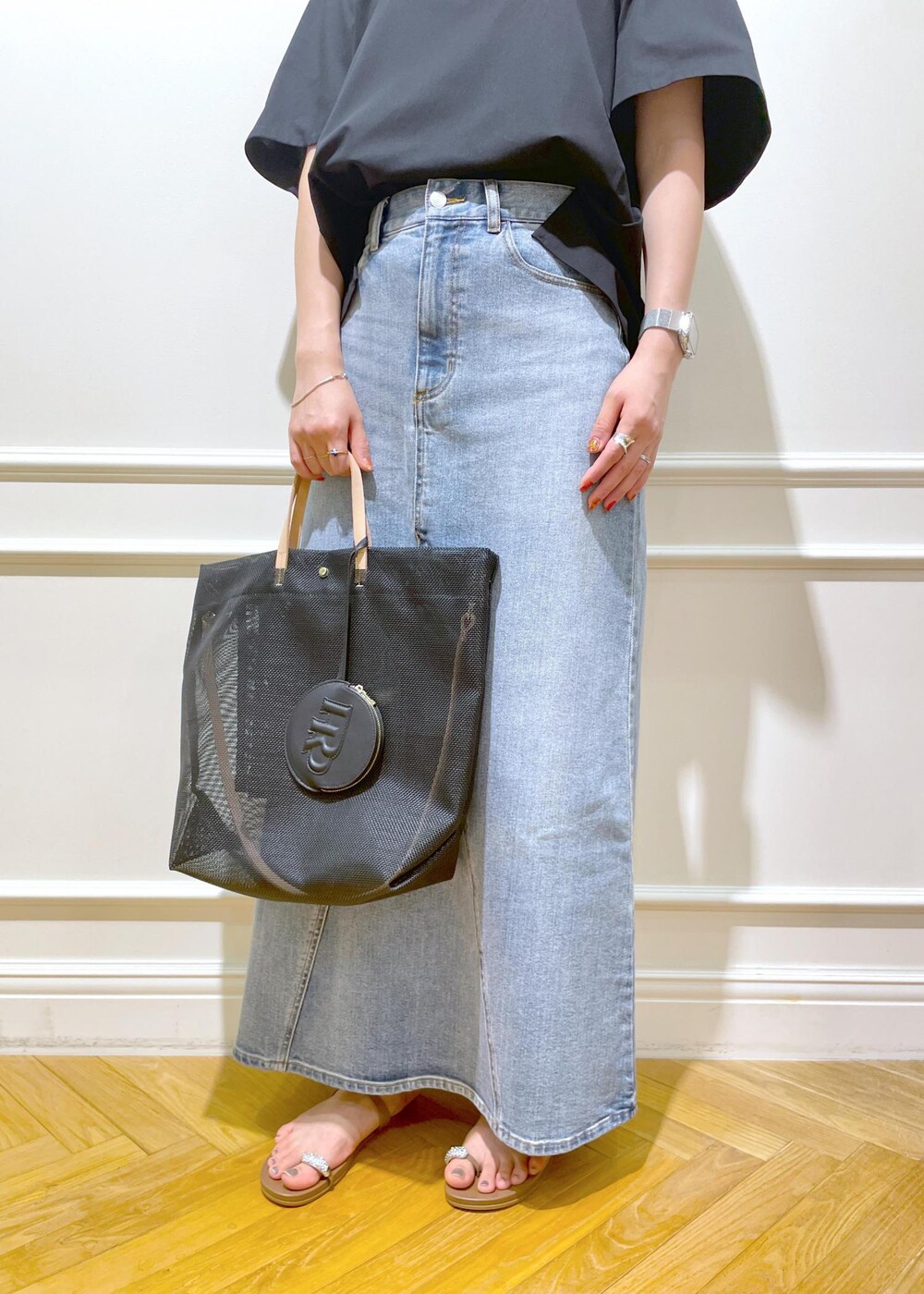 ブラック系のトートバッグ、ベージュ系のサンダル、ブラック系のTシャツ/カットソーを着用したレディースの夏コーディネートの8枚目の写真