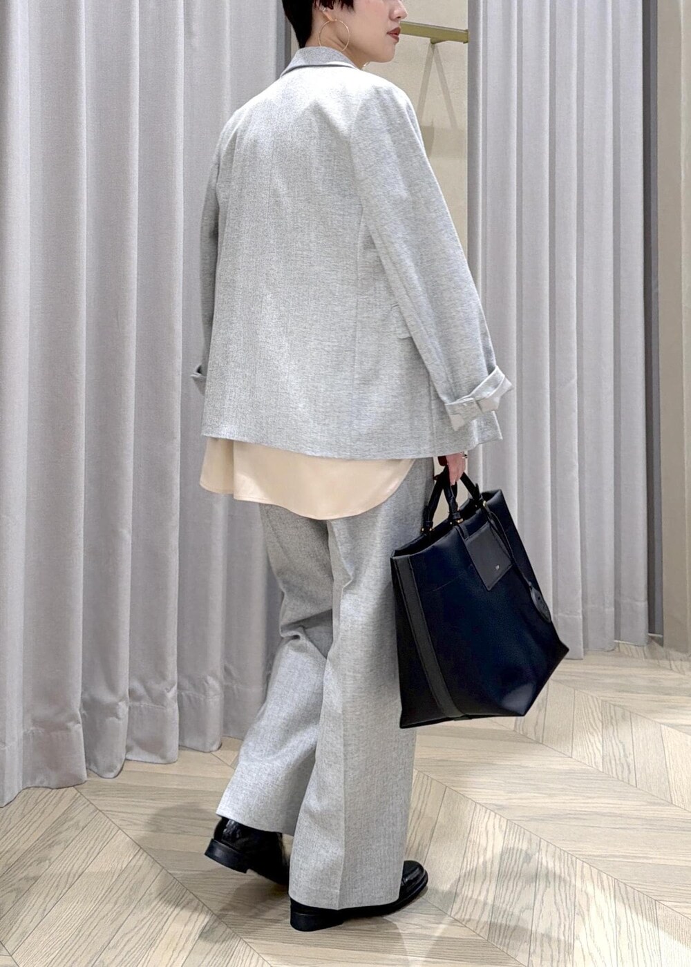 ブラック系のドレスシューズ、ブラック系のトートバッグ、グレー系のテーラードジャケットを着用したレディースの秋コーディネートの5枚目の写真