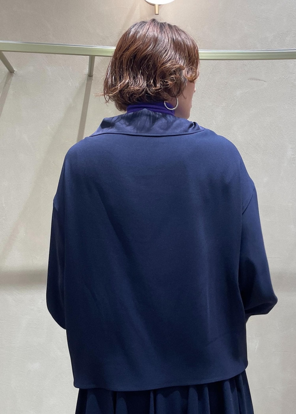 ブラック系のブーツ、ベージュ系のハンドバッグ、ブルー系のスカートを着用したレディースの冬コーディネートの8枚目の写真