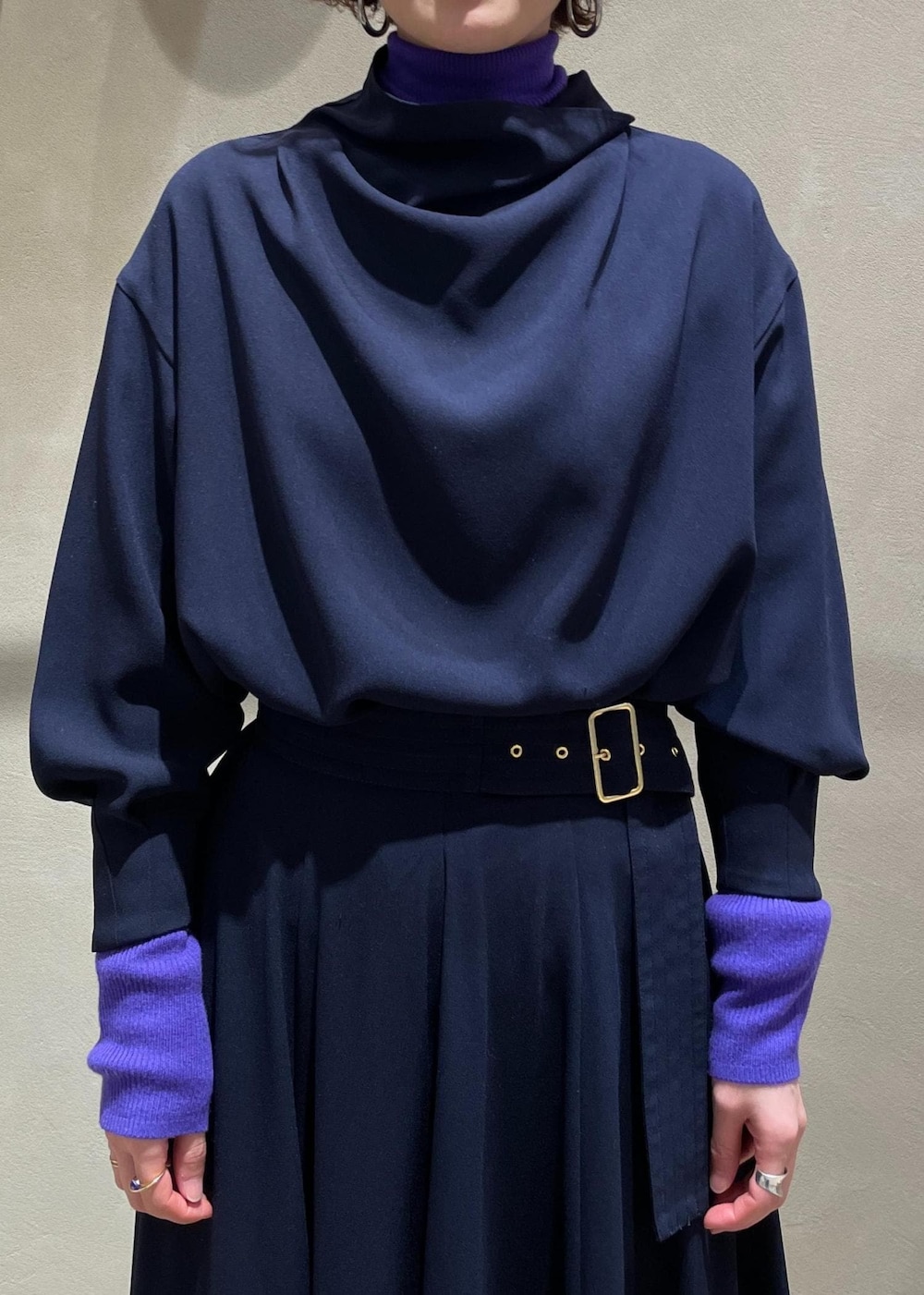 ブラック系のブーツ、ベージュ系のハンドバッグ、ブルー系のスカートを着用したレディースの冬コーディネートの6枚目の写真