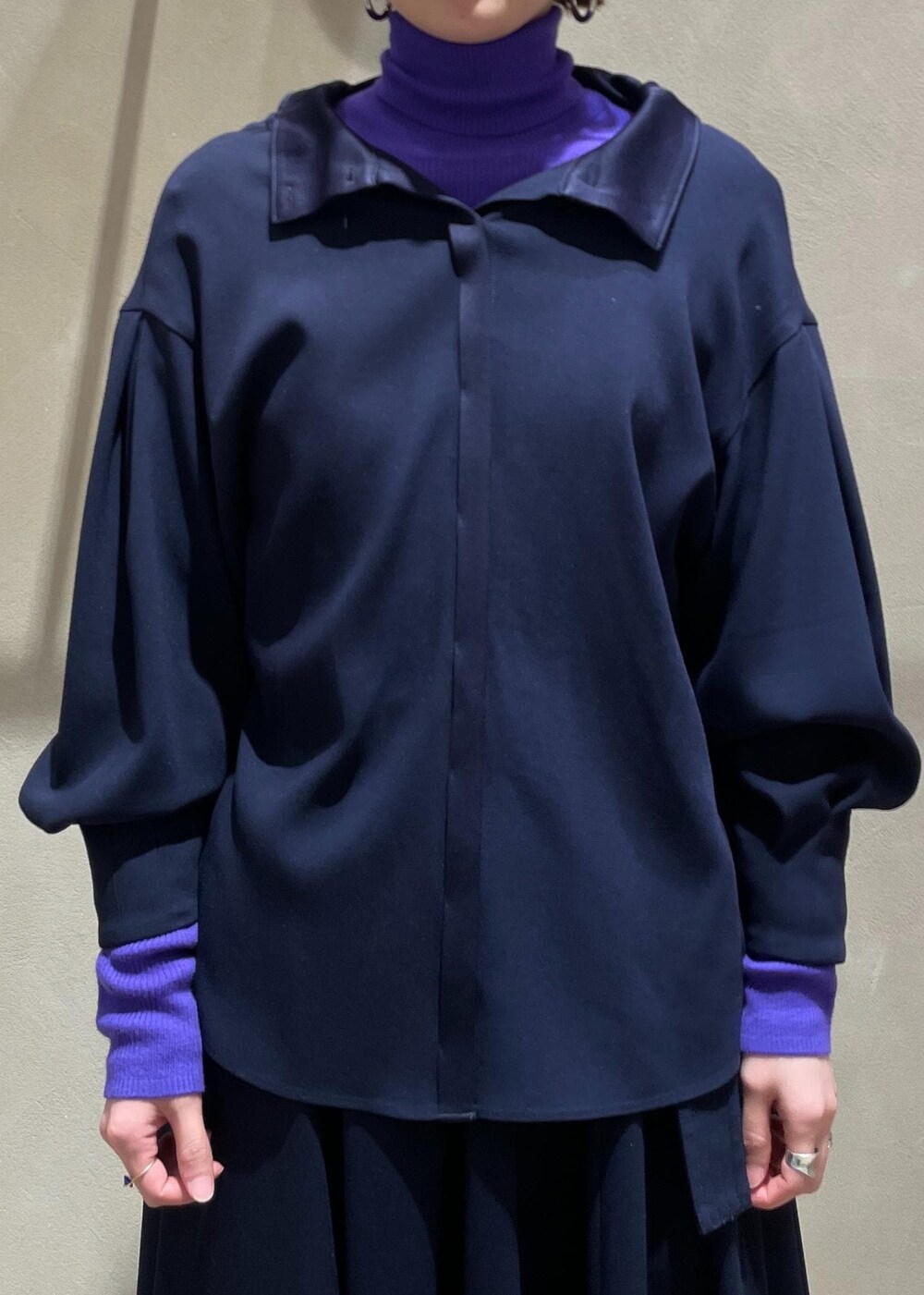 ブラック系のブーツ、ベージュ系のハンドバッグ、ブルー系のスカートを着用したレディースの冬コーディネートの7枚目の写真