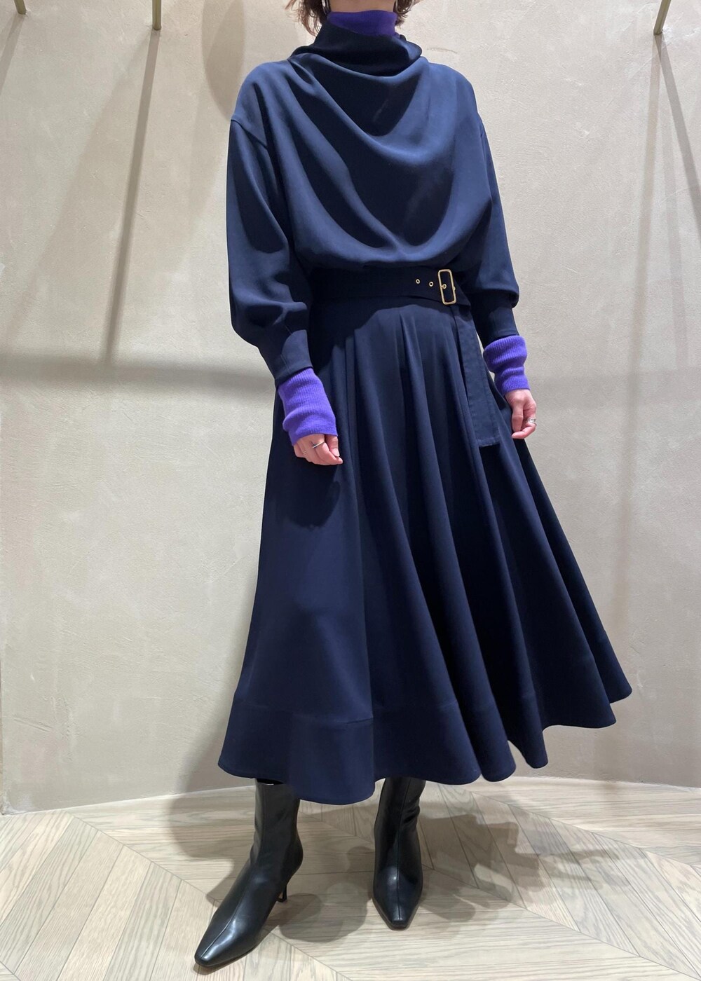 ブラック系のブーツ、ベージュ系のハンドバッグ、ブルー系のスカートを着用したレディースの冬コーディネートの9枚目の写真