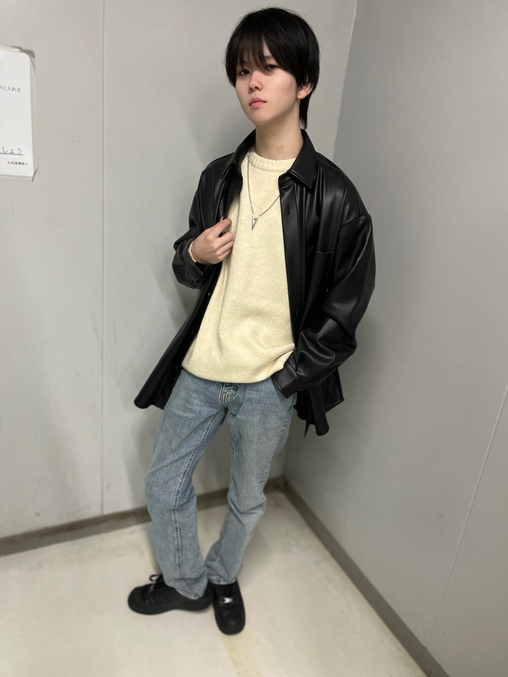 ブラック系のその他アウター、ホワイト系のニット/セーター、ブルー系のデニムパンツを着用したメンズの秋コーディネートの2枚目の写真