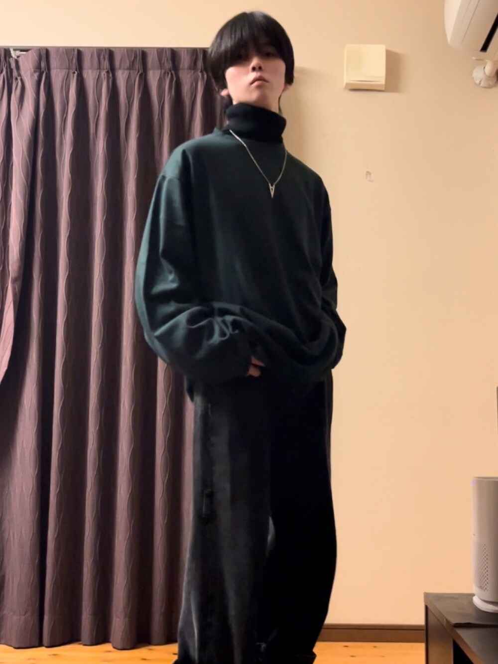 グリーン系のTシャツ/カットソー、ブラック系のデニムパンツ、ブラック系のニット/セーターを着用したメンズの秋コーディネートの2枚目の写真