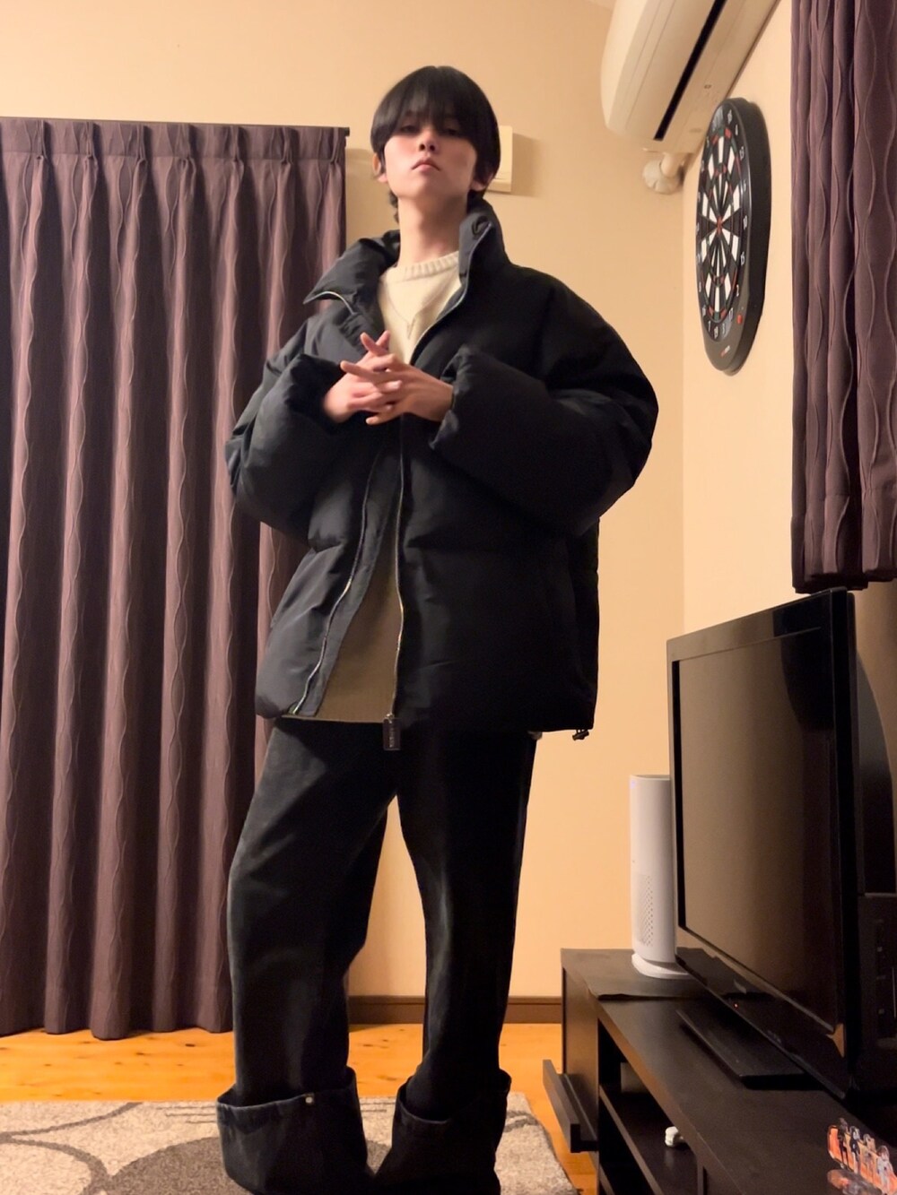 ブラック系のダウンジャケット/コート、ホワイト系のニット/セーター、ブラック系のデニムパンツを着用したメンズの冬コーディネートの2枚目の写真