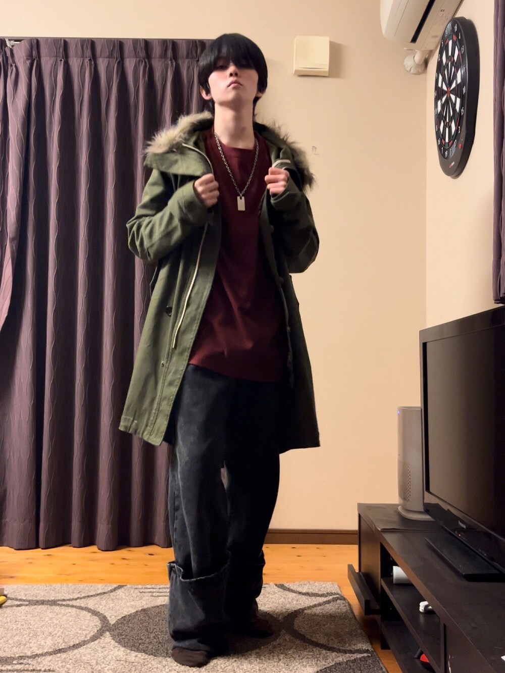 レッド系のTシャツ/カットソー、ブラック系のデニムパンツ、グリーン系のモッズコートを着用したメンズの冬コーディネートの2枚目の写真