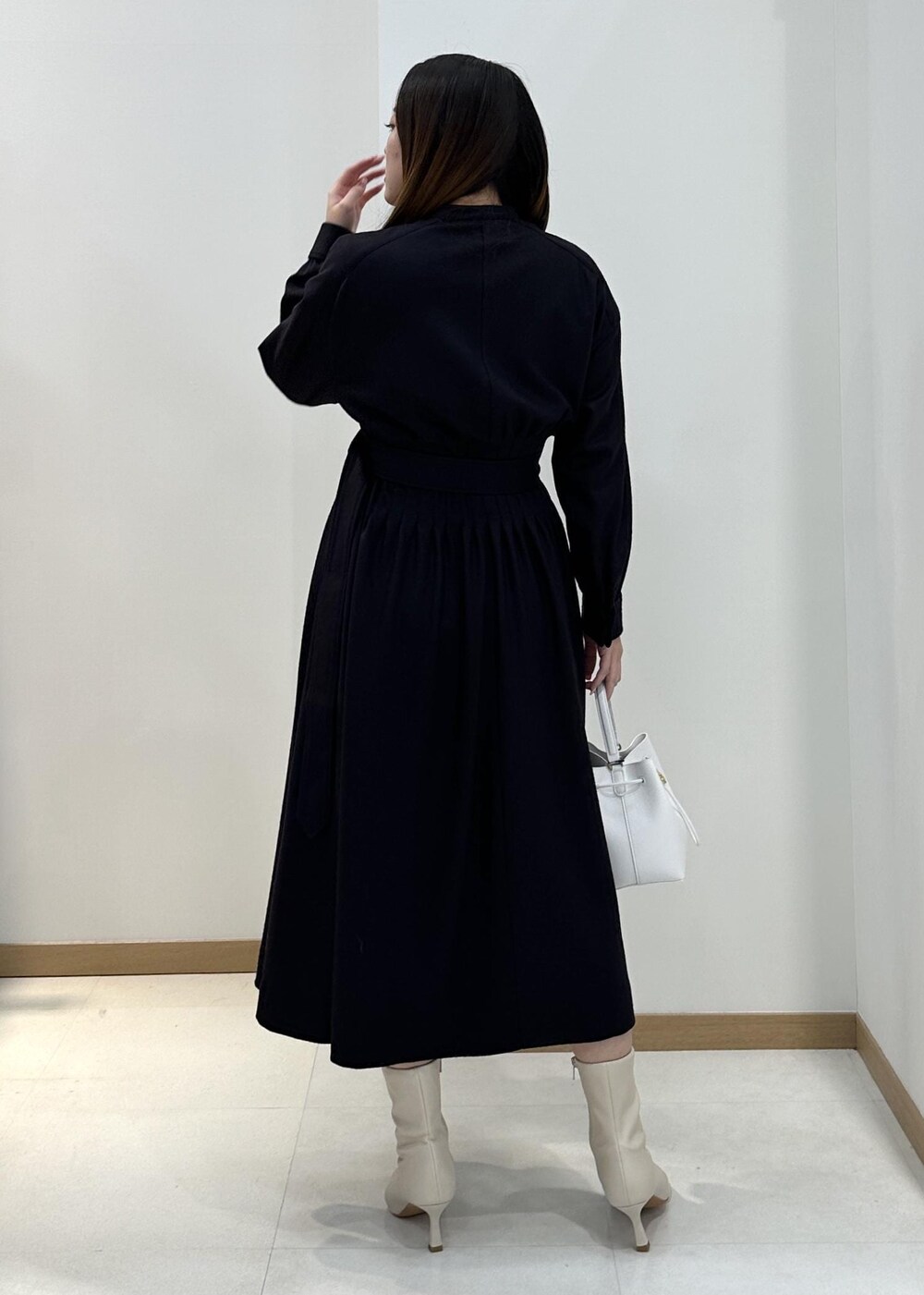 ホワイト系のブーツ、ホワイト系のハンドバッグ、ブルー系のワンピースを着用したレディースの冬コーディネートの3枚目の写真