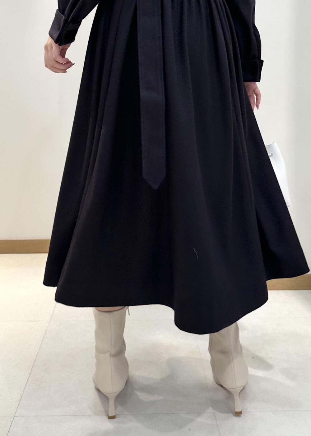 ホワイト系のブーツ、ホワイト系のハンドバッグ、ブルー系のワンピースを着用したレディースの冬コーディネートの7枚目の写真