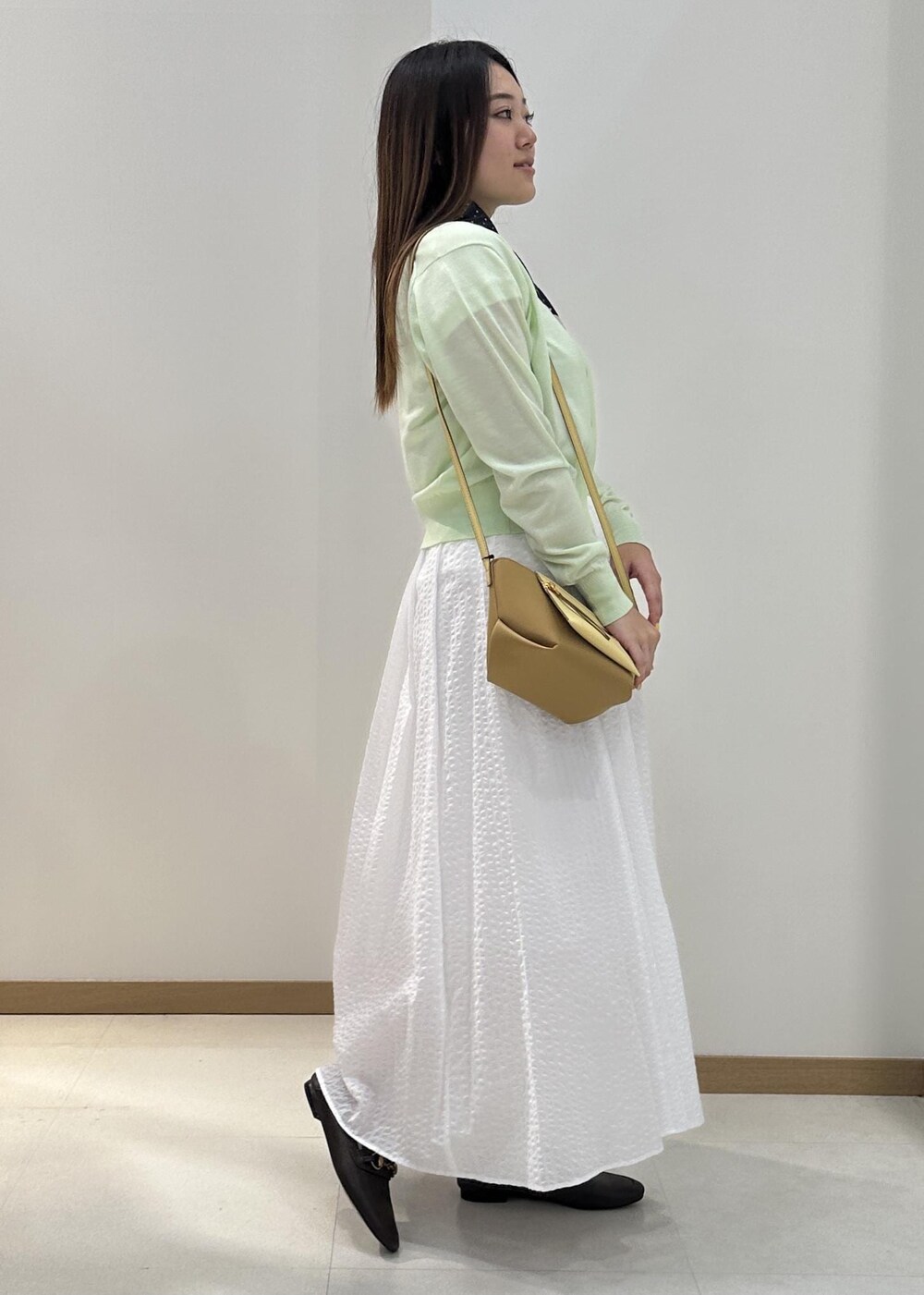 ホワイト系のTシャツ/カットソー、グリーン系のカーディガン/ボレロ、イエロー系のショルダーバッグを着用したレディースの夏コーディネートの2枚目の写真