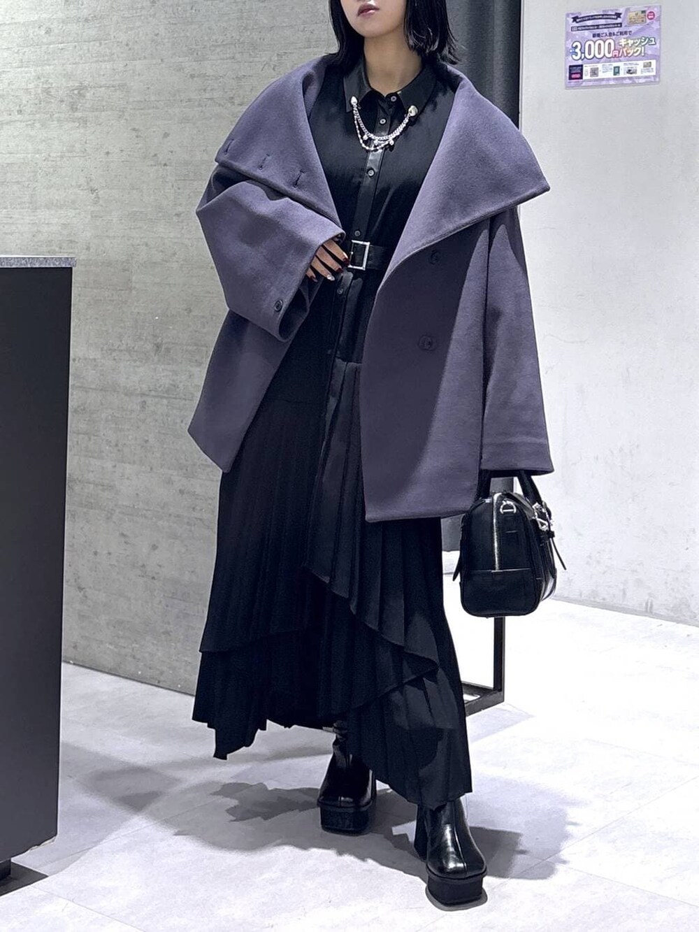 パープル系のチェスターコート、ブラック系のボストンバッグ、ブラック系のブーツを着用したレディースの冬コーディネートの9枚目の写真
