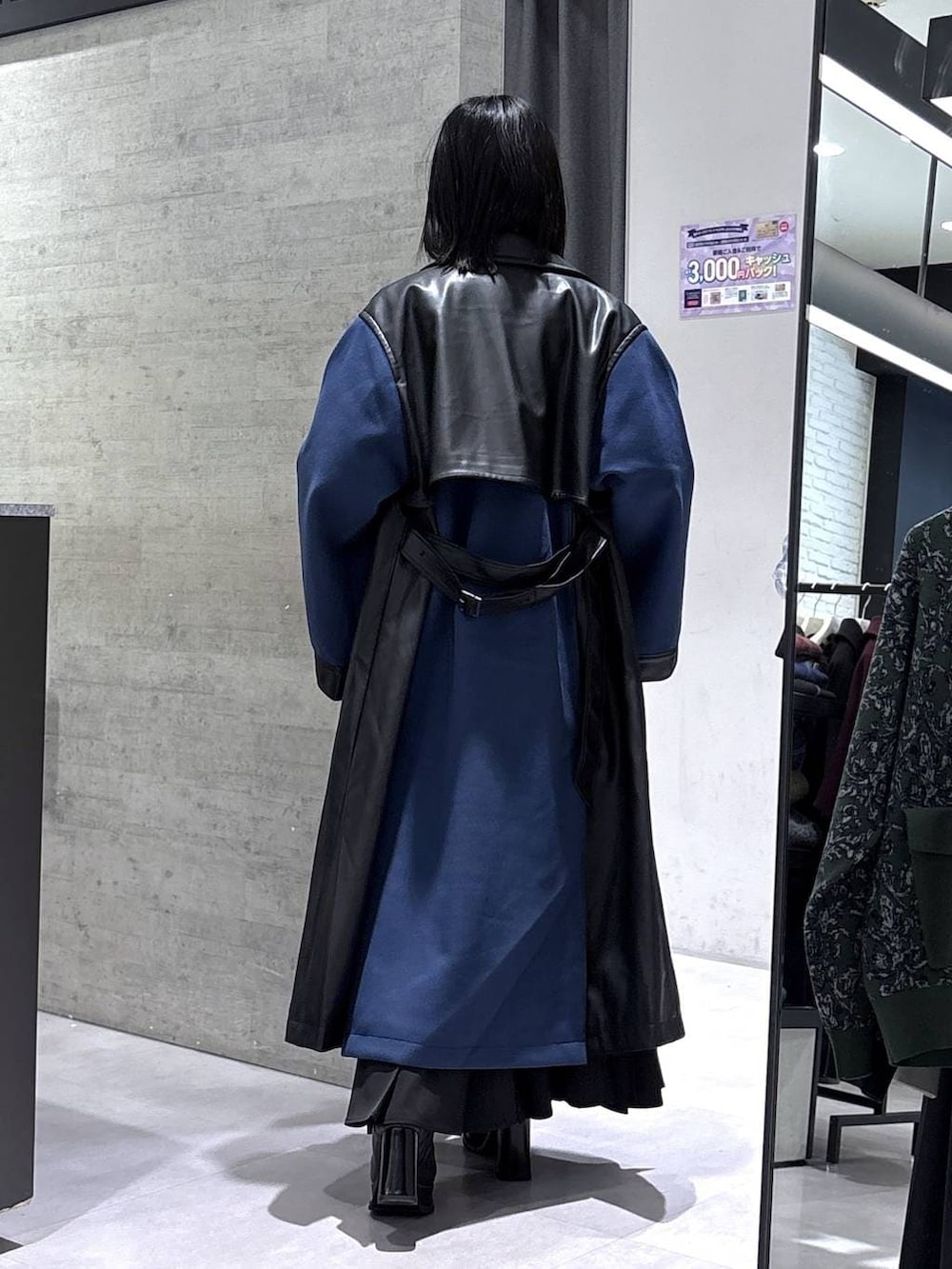 ブラック系のネクタイ、ブルー系のチェスターコート、ブルー系のニット/セーターを着用したレディースの冬コーディネートの7枚目の写真