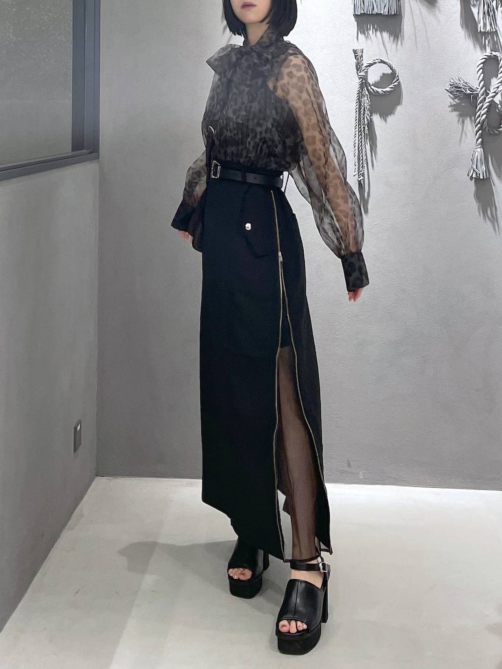 ブラック系のタンクトップ、ブラック系のサンダル、ブラウン系のショルダーバッグを着用したレディースの夏コーディネートの9枚目の写真