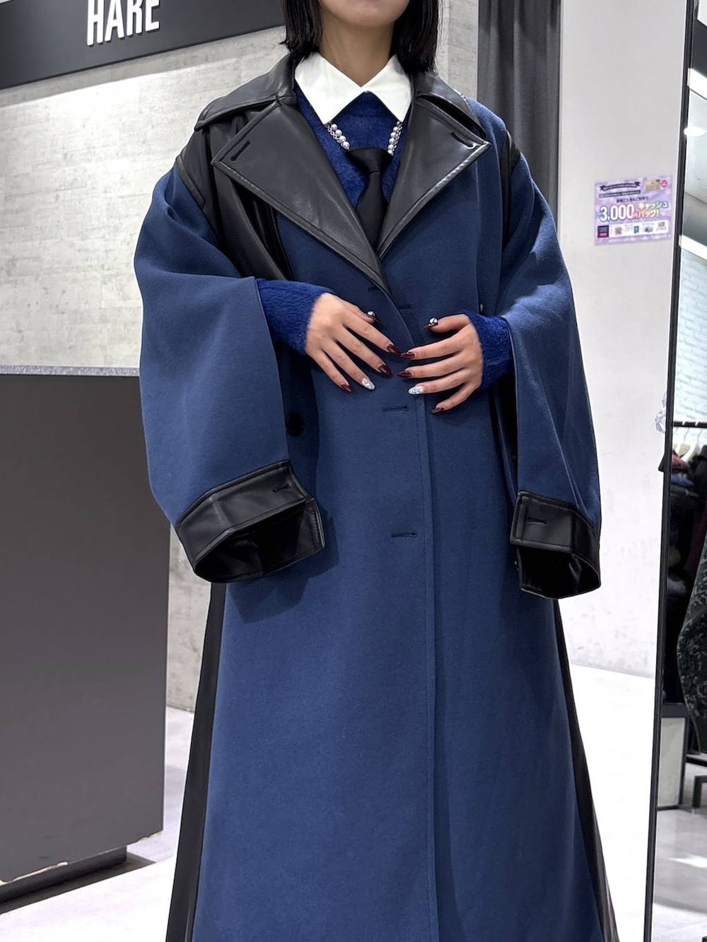 ブラック系のネクタイ、ブルー系のチェスターコート、ブルー系のニット/セーターを着用したレディースの冬コーディネートの2枚目の写真