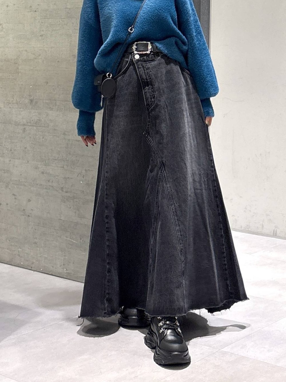 グレー系のタンクトップ、ブルー系のニット/セーター、ブラック系のブーツを着用したレディースの秋コーディネートの3枚目の写真