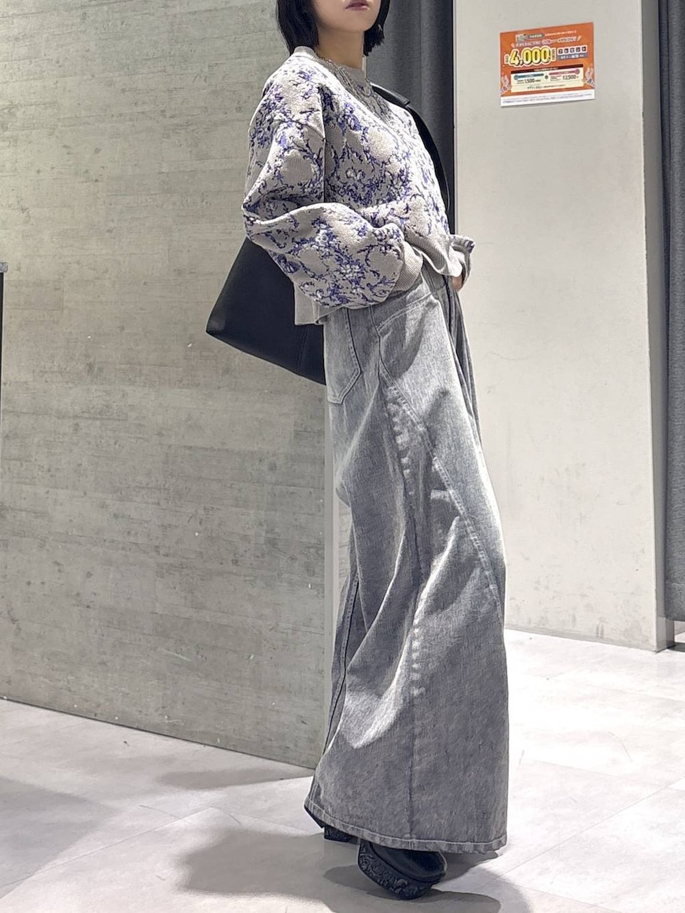 グレー系のタンクトップ、ブラック系のトートバッグ、グレー系のブーツを着用したレディースの秋コーディネートの4枚目の写真