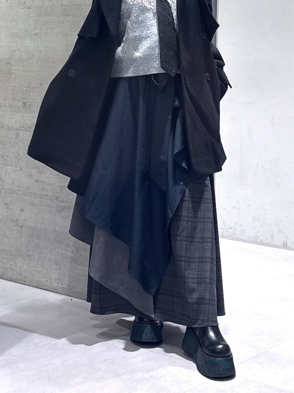 ブラック系のネクタイ、ブラック系のトレンチコート、グリーン系のブーツを着用したレディースの秋コーディネートの3枚目の写真