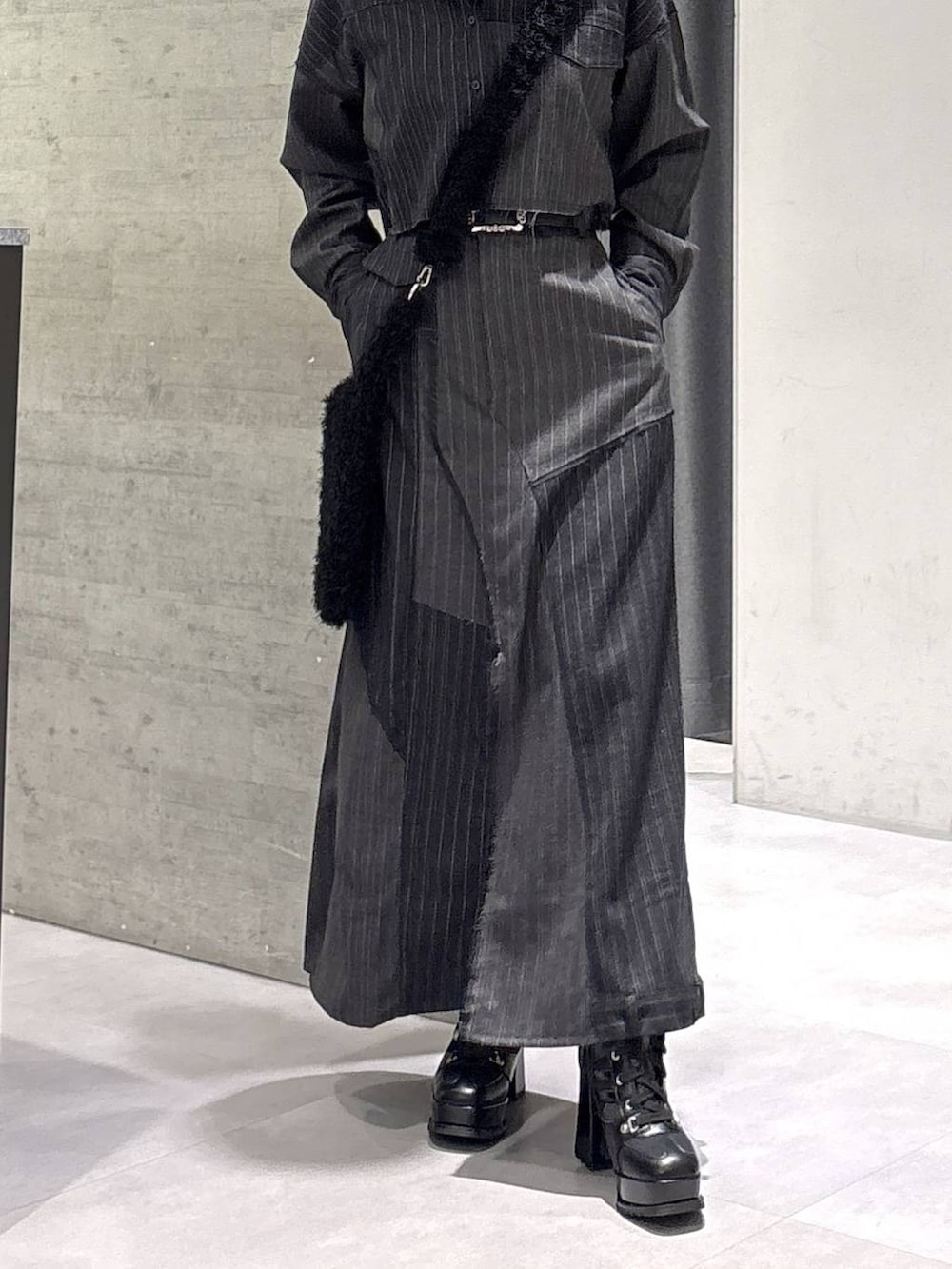 レッド系のニット/セーター、ブラック系のブーツ、ブラック系のショルダーバッグを着用したレディースの秋コーディネートの3枚目の写真