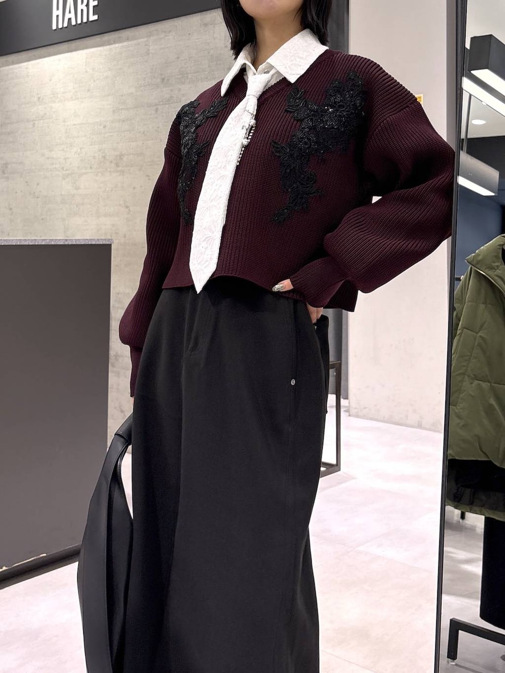 ブラック系のトートバッグ、ブラック系のブーツ、レッド系のニット/セーターを着用したレディースの秋コーディネートの8枚目の写真