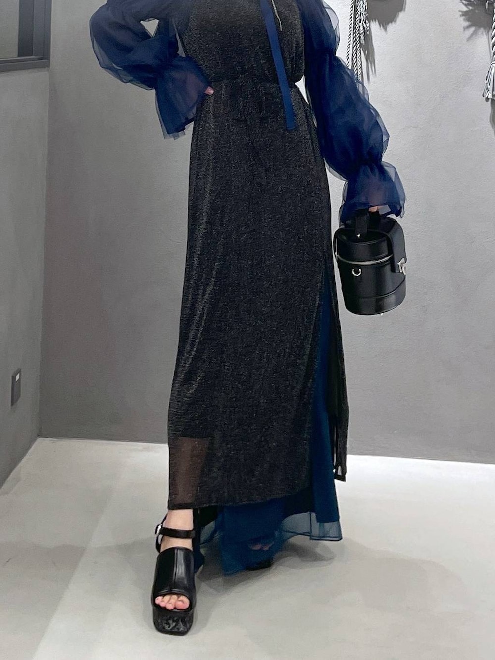 ブラック系のタンクトップ、グレー系のサンダル、ブラック系のショルダーバッグを着用したレディースの夏コーディネートの3枚目の写真