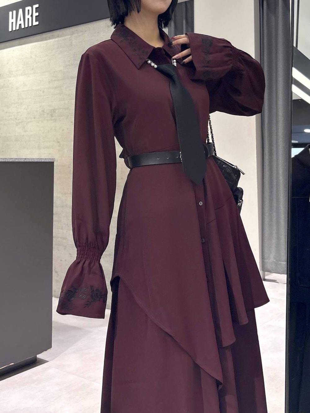 ブラック系のネクタイ、グレー系のタンクトップ、ブラック系のブーツを着用したレディースの秋コーディネートの8枚目の写真