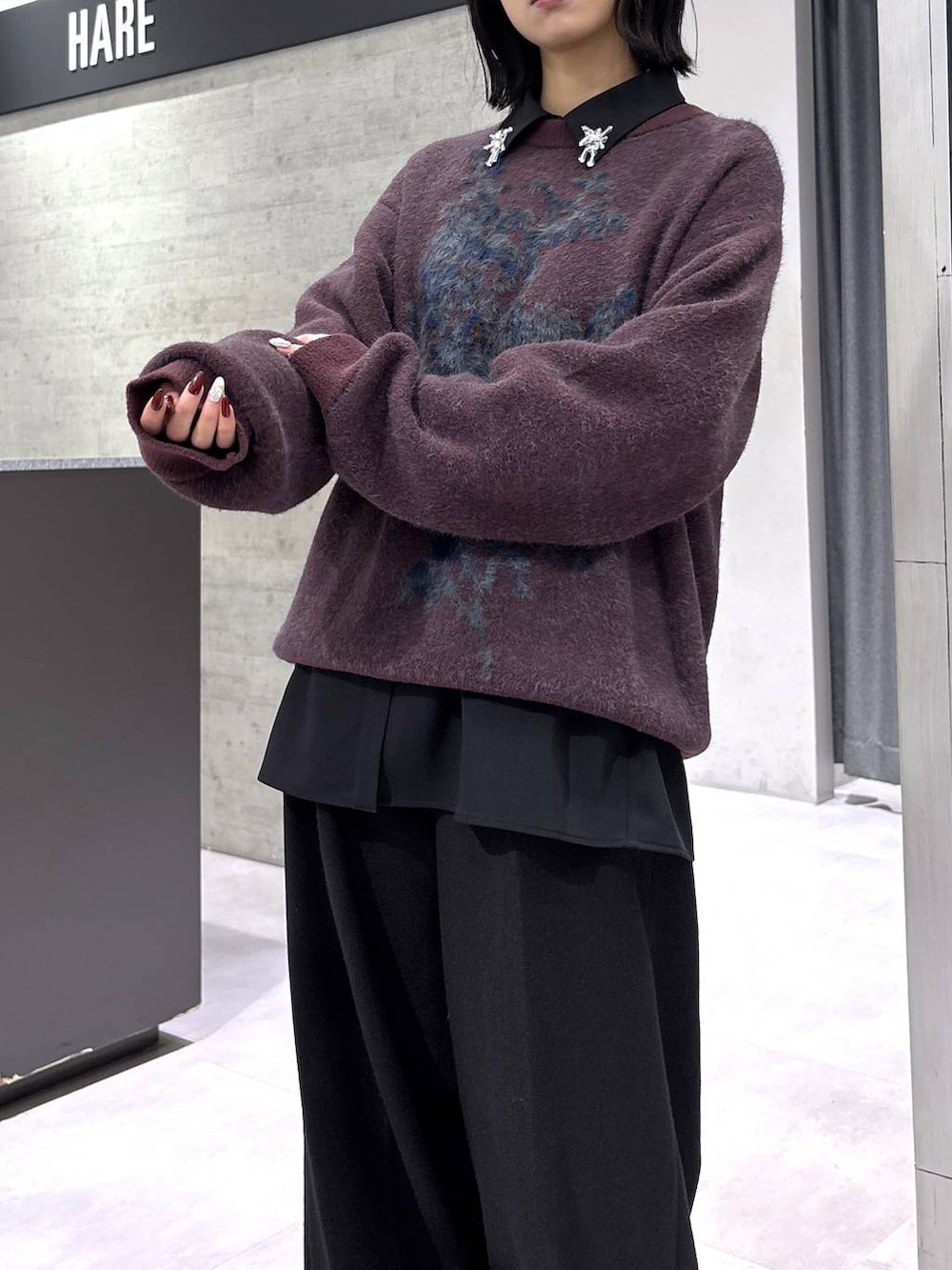 ブラック系のブーツ、レッド系のニット/セーター、ブラック系のスラックスを着用したレディースの秋コーディネートの8枚目の写真