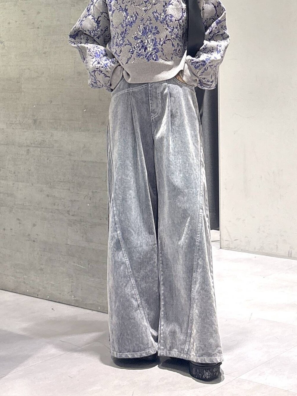 グレー系のタンクトップ、ブラック系のトートバッグ、グレー系のブーツを着用したレディースの秋コーディネートの3枚目の写真