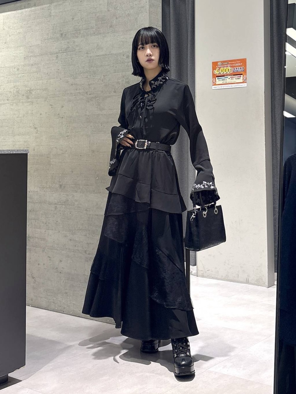 ブラック系のショルダーバッグ、ブラック系のシャツ/ブラウス、ブラック系のブーツを着用したレディースの秋コーディネートの5枚目の写真