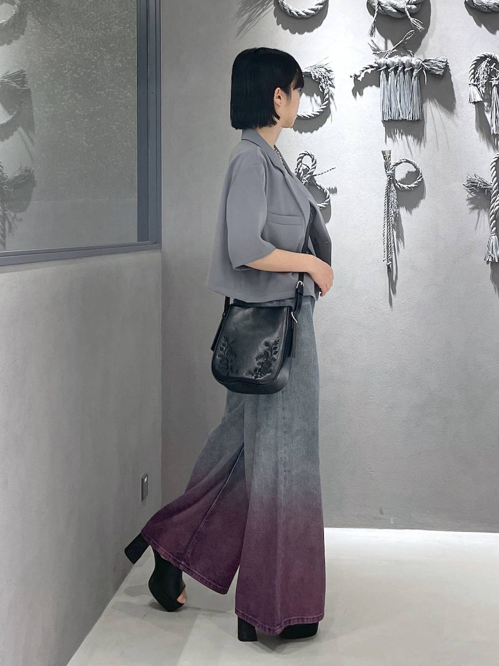 ブラック系のタンクトップ、ブラック系のサンダル、パープル系のデニムパンツを着用したレディースの夏コーディネートの6枚目の写真