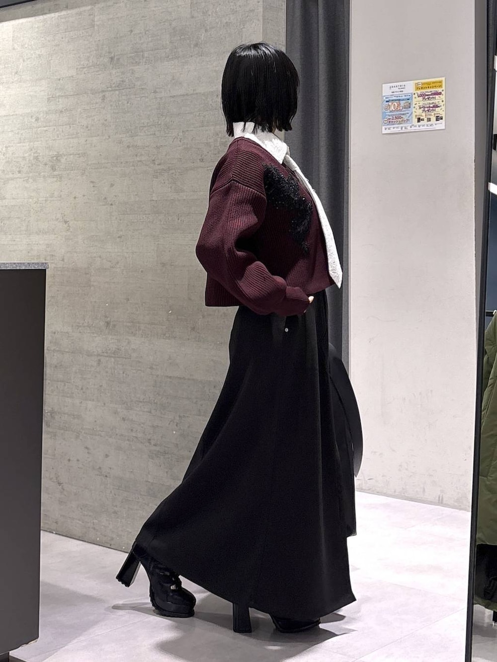 ブラック系のトートバッグ、ブラック系のブーツ、レッド系のニット/セーターを着用したレディースの秋コーディネートの6枚目の写真