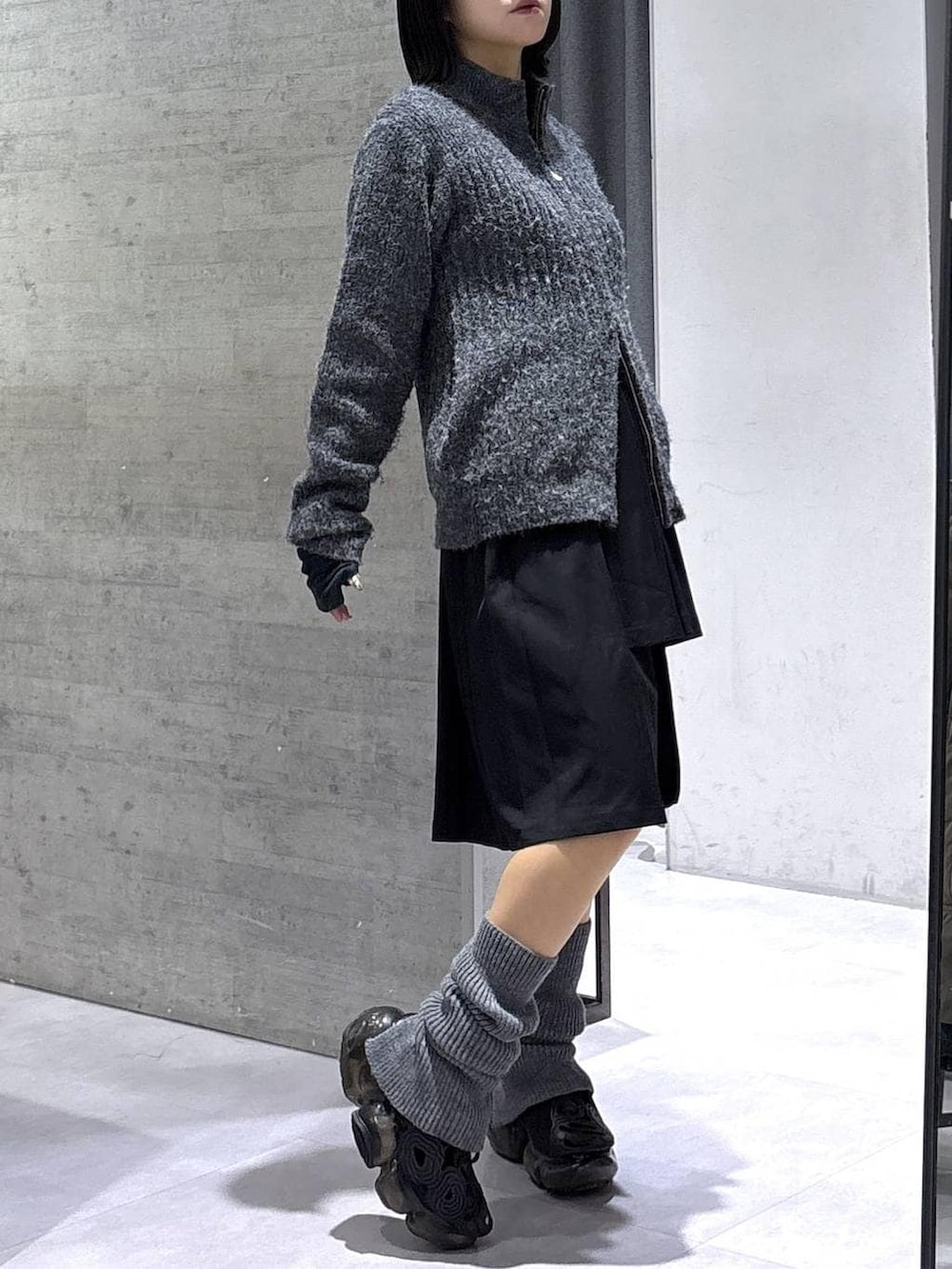 ブラック系のスカート、グレー系のカーディガン/ボレロ、ブラック系のベルトを着用したレディースの冬コーディネートの4枚目の写真