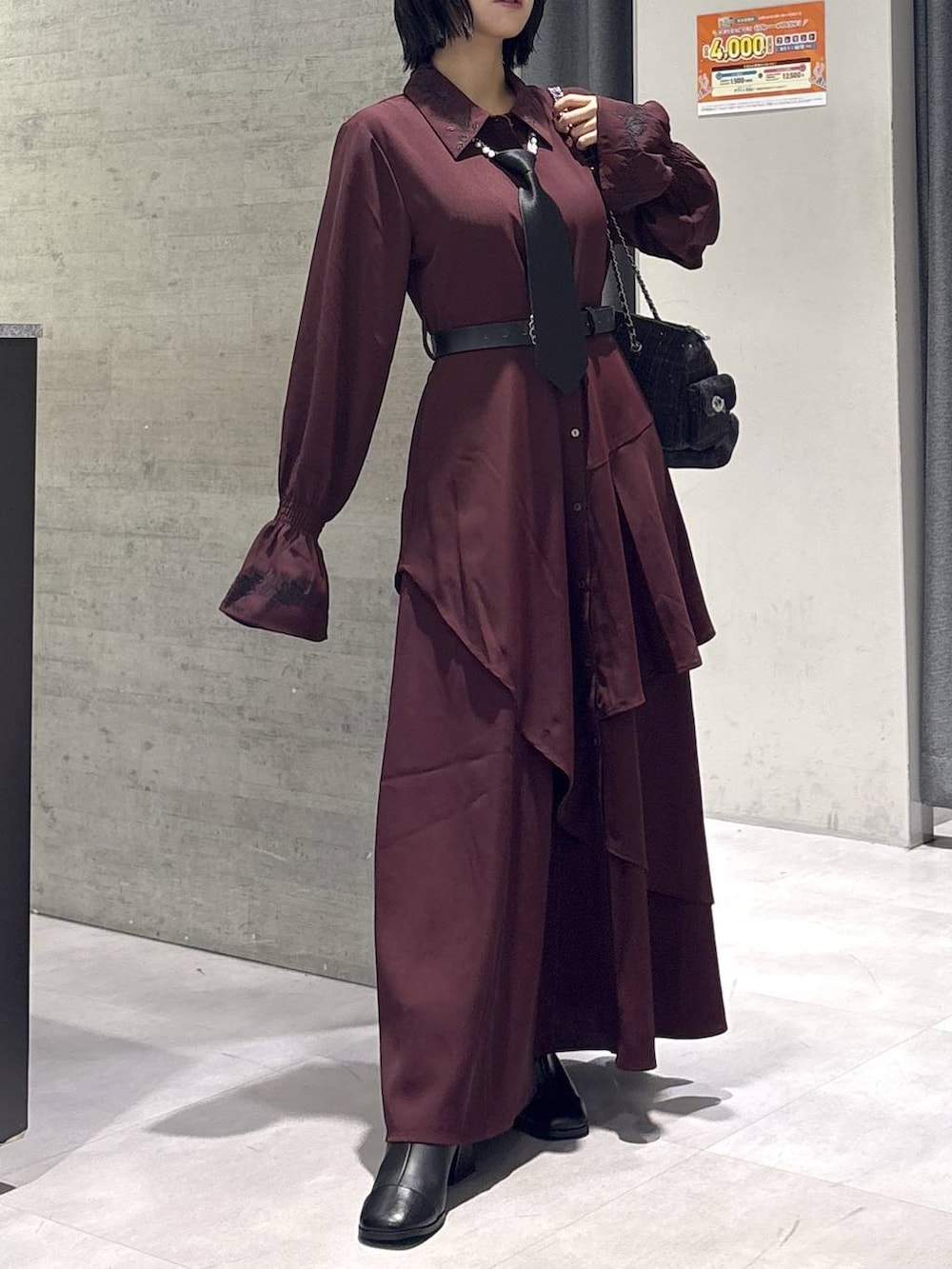 ブラック系のネクタイ、グレー系のタンクトップ、ブラック系のブーツを着用したレディースの秋コーディネートの4枚目の写真