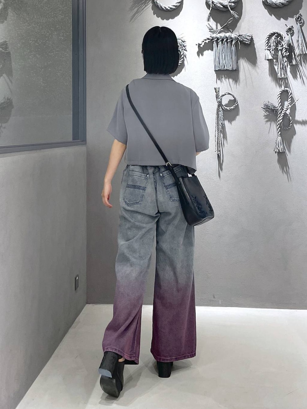 ブラック系のタンクトップ、ブラック系のサンダル、パープル系のデニムパンツを着用したレディースの夏コーディネートの7枚目の写真