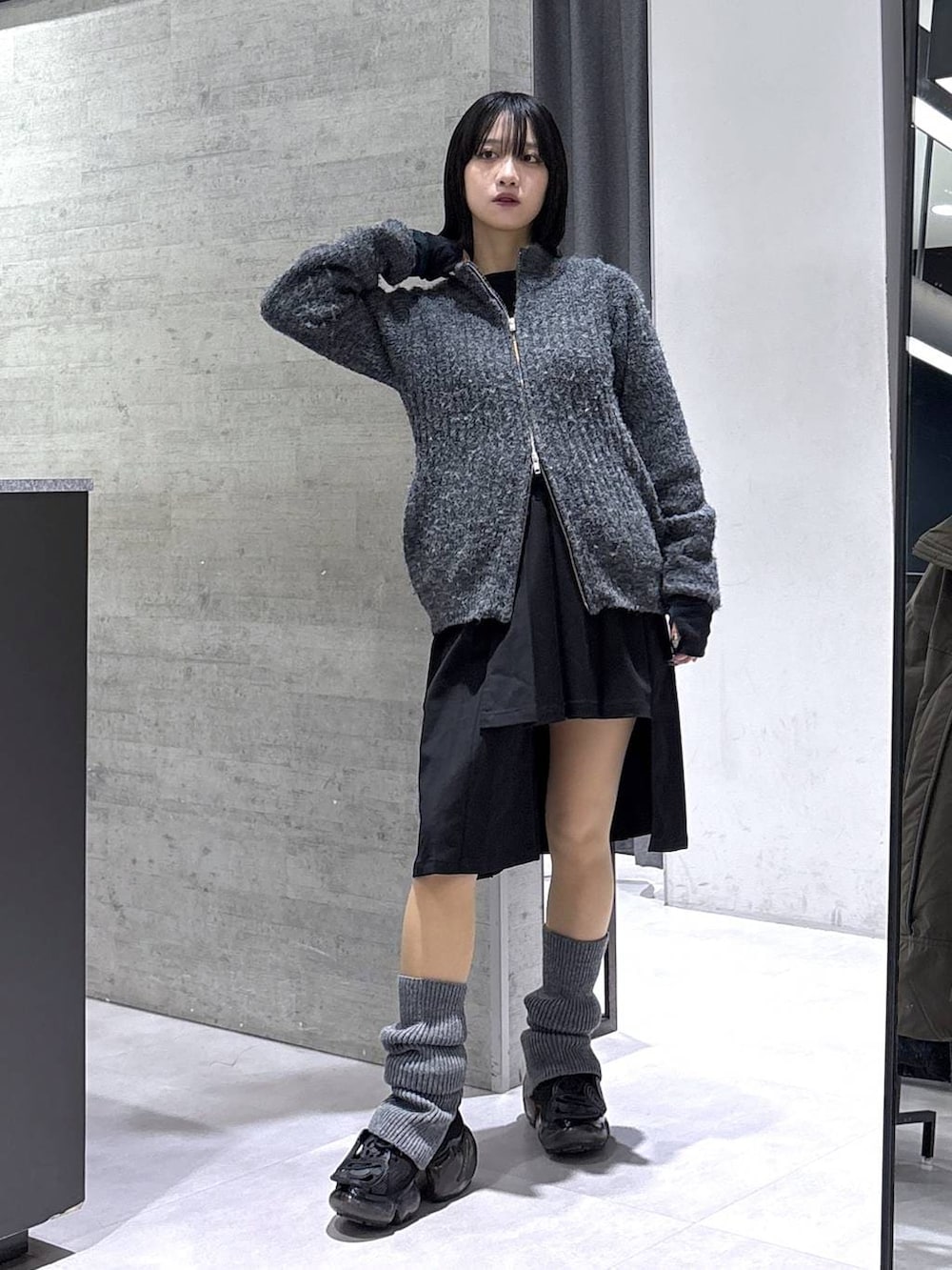 ブラック系のスカート、グレー系のカーディガン/ボレロ、ブラック系のベルトを着用したレディースの冬コーディネートの5枚目の写真