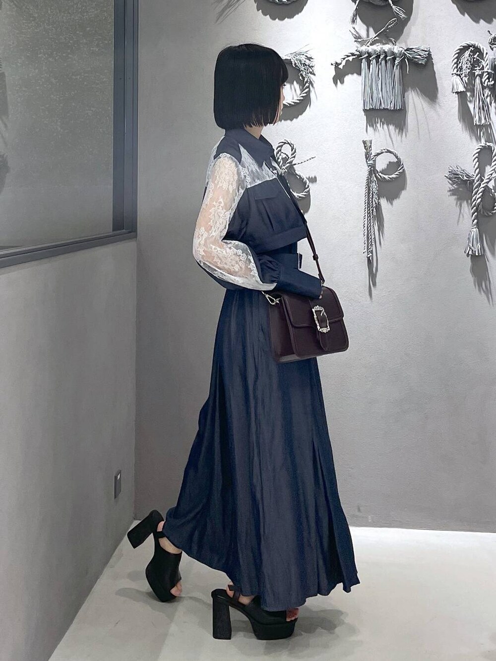 ブラック系のタンクトップ、ブラック系のサンダル、ブラウン系のショルダーバッグを着用したレディースの夏コーディネートの6枚目の写真