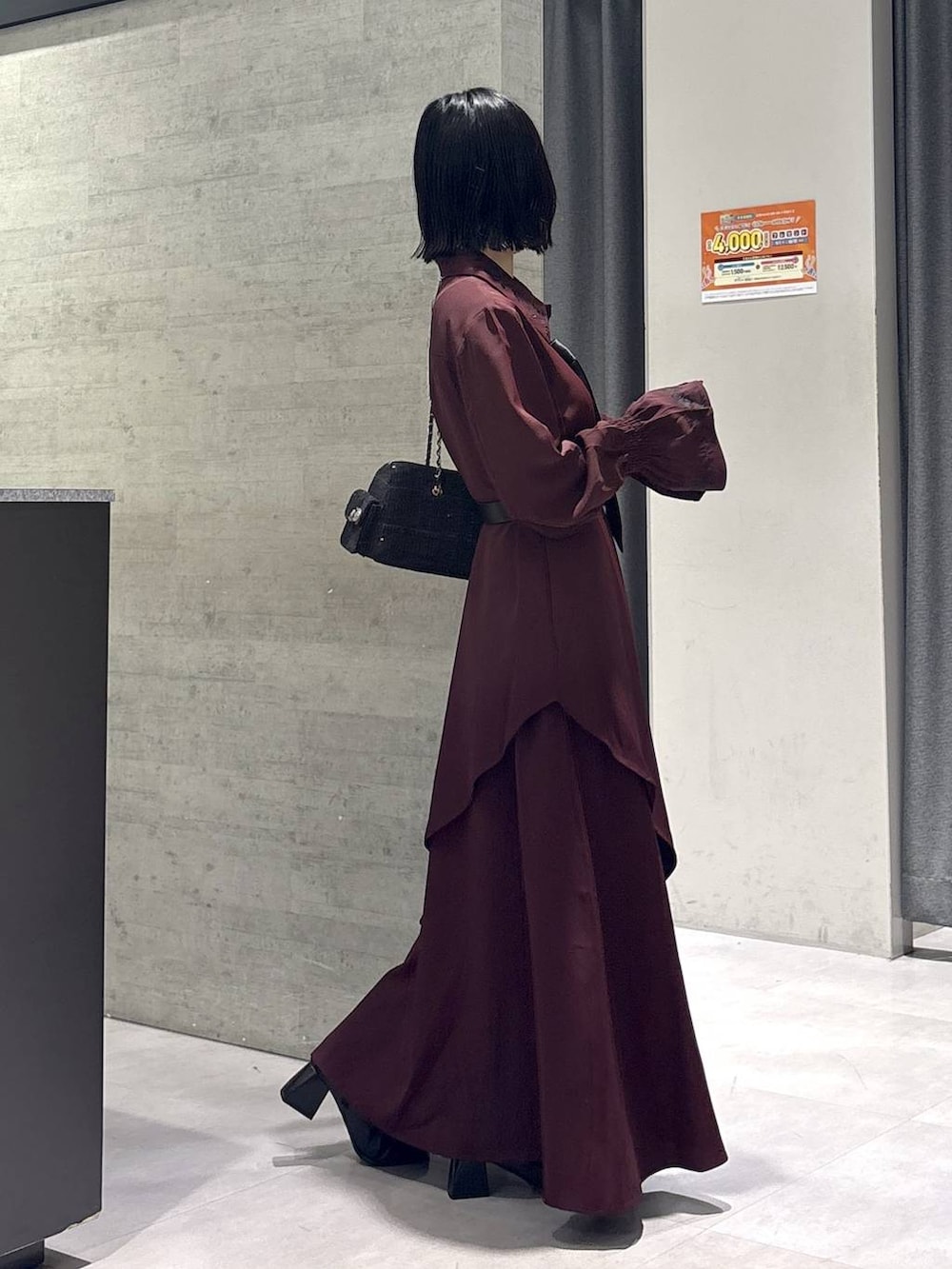 ブラック系のネクタイ、グレー系のタンクトップ、ブラック系のブーツを着用したレディースの秋コーディネートの6枚目の写真