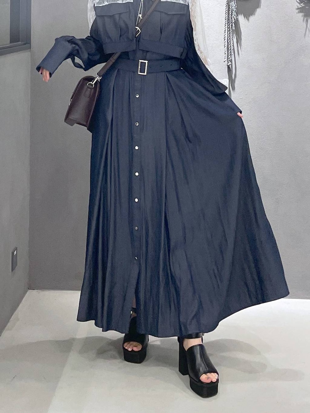 ブラック系のタンクトップ、ブラック系のサンダル、ブラウン系のショルダーバッグを着用したレディースの夏コーディネートの3枚目の写真