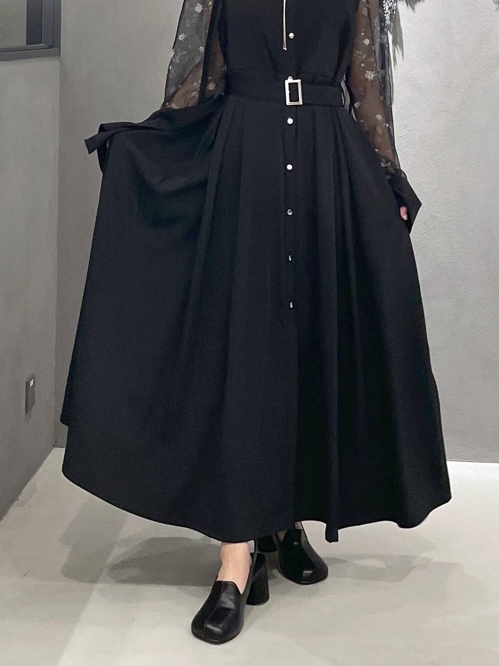 グレー系のタンクトップ、ブラック系のパンプス、ブラック系のショルダーバッグを着用したレディースの夏コーディネートの3枚目の写真