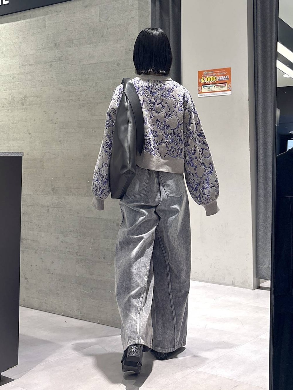 グレー系のタンクトップ、ブラック系のトートバッグ、グレー系のブーツを着用したレディースの秋コーディネートの7枚目の写真