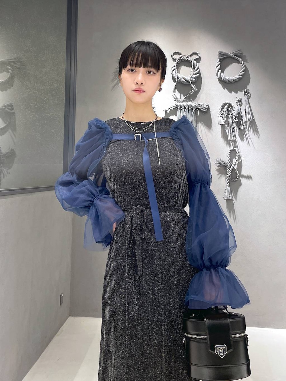 ブラック系のタンクトップ、グレー系のサンダル、ブラック系のショルダーバッグを着用したレディースの夏コーディネートの2枚目の写真