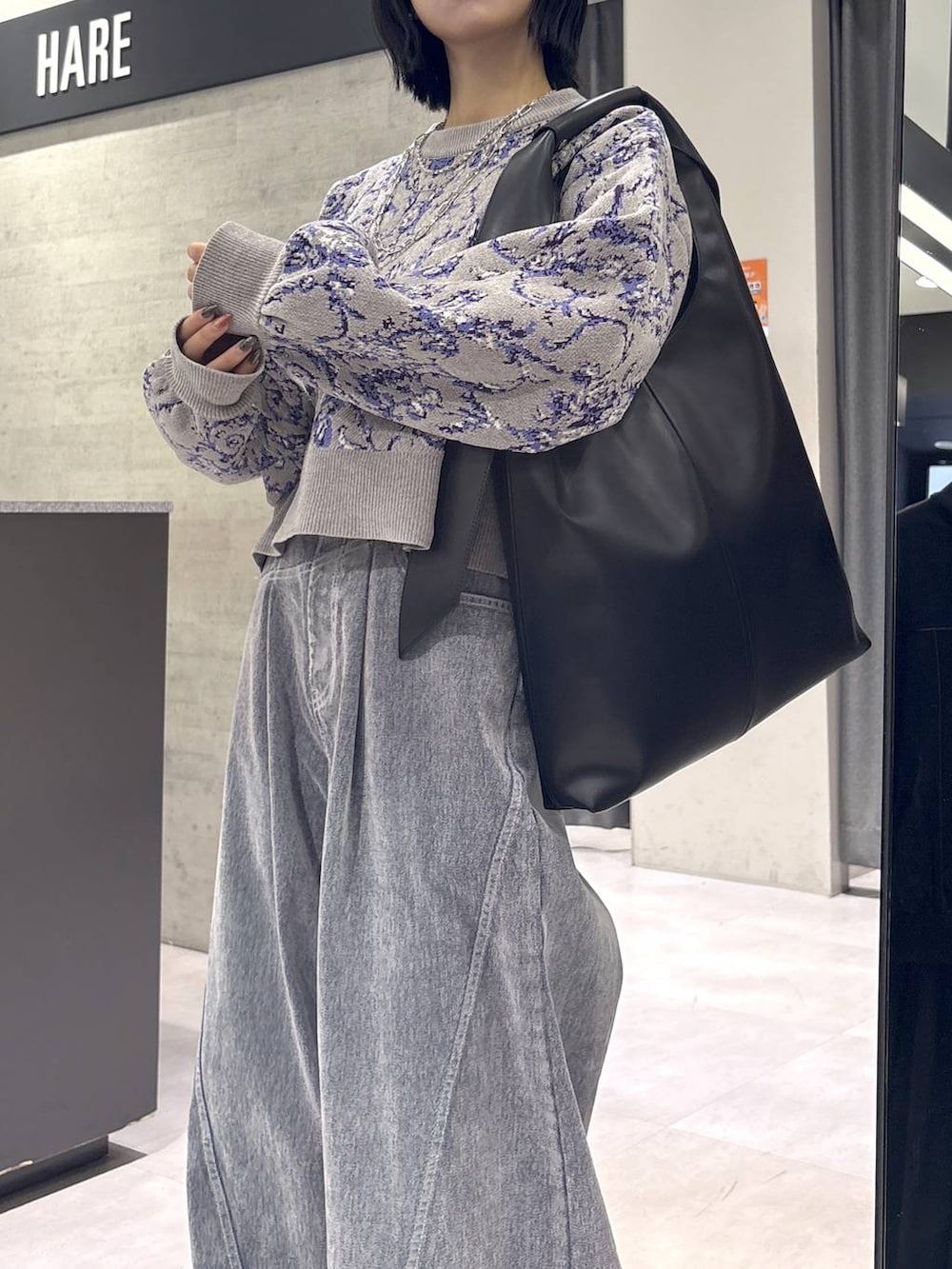 グレー系のタンクトップ、ブラック系のトートバッグ、グレー系のブーツを着用したレディースの秋コーディネートの8枚目の写真