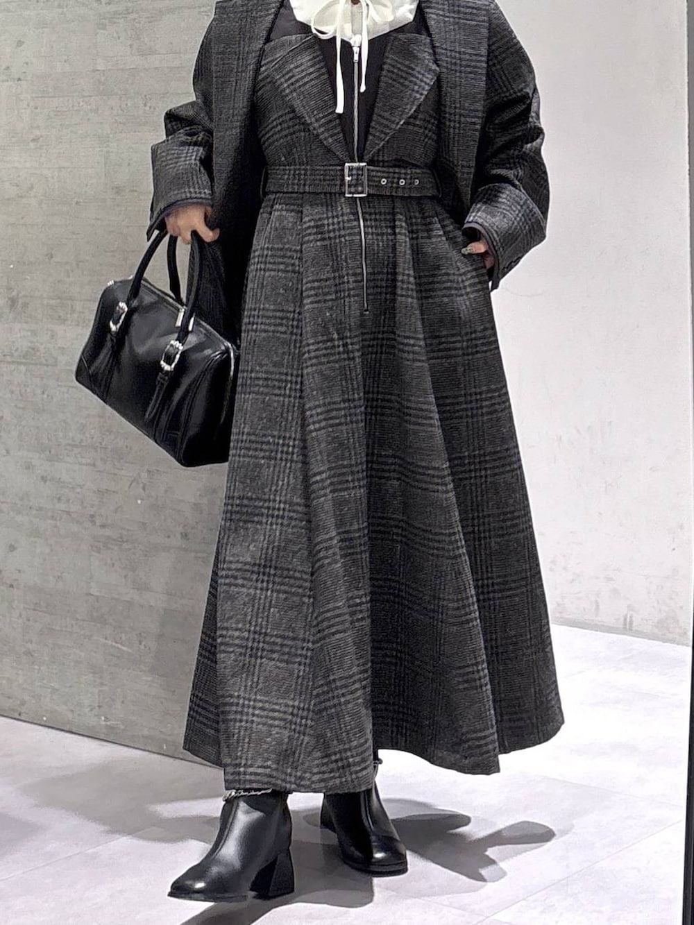 ホワイト系のタンクトップ、ブラック系のボストンバッグ、ホワイト系のシャツ/ブラウスを着用したレディースの秋コーディネートの3枚目の写真