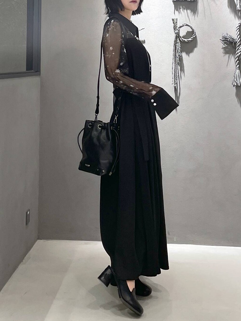 グレー系のタンクトップ、ブラック系のパンプス、ブラック系のショルダーバッグを着用したレディースの夏コーディネートの4枚目の写真