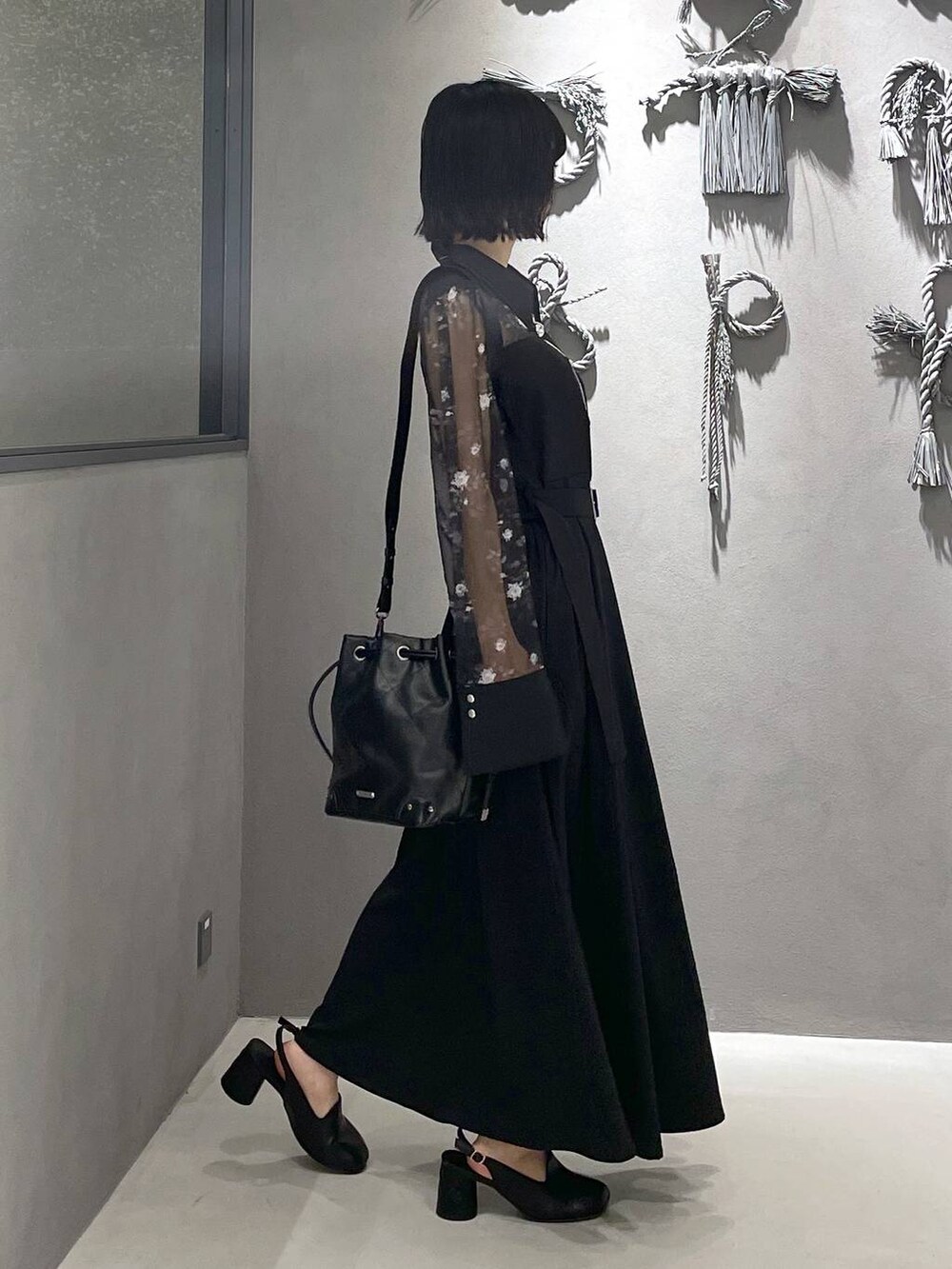 グレー系のタンクトップ、ブラック系のパンプス、ブラック系のショルダーバッグを着用したレディースの夏コーディネートの6枚目の写真