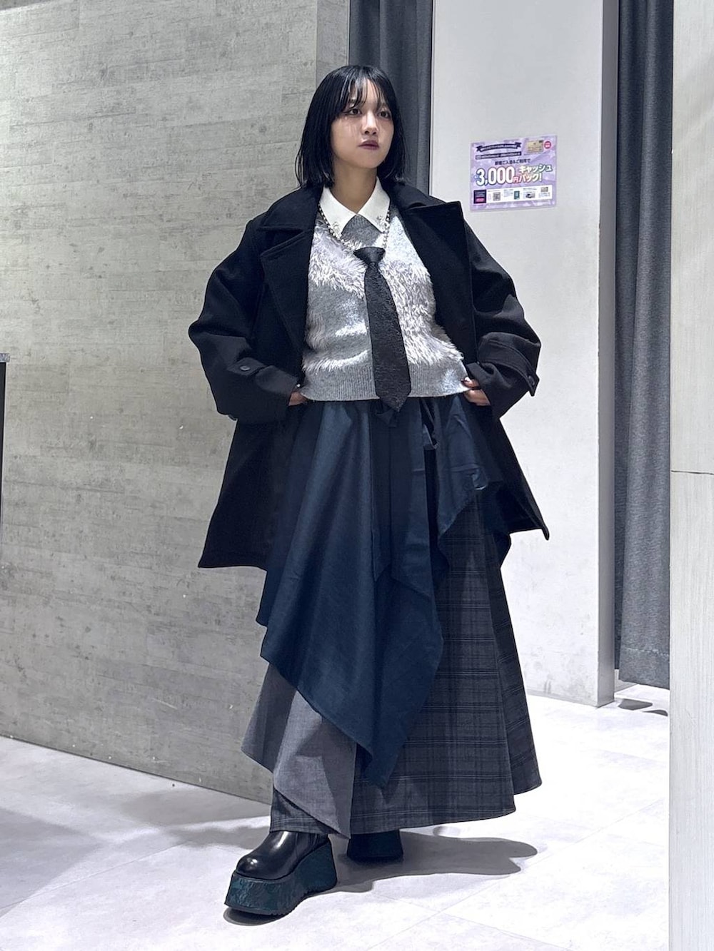 ブラック系のネクタイ、ブラック系のトレンチコート、グリーン系のブーツを着用したレディースの秋コーディネートの5枚目の写真