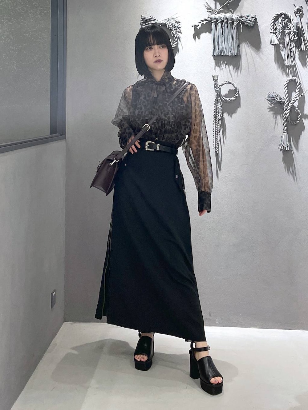 ブラック系のタンクトップ、ブラック系のサンダル、ブラウン系のショルダーバッグを着用したレディースの夏コーディネートの5枚目の写真