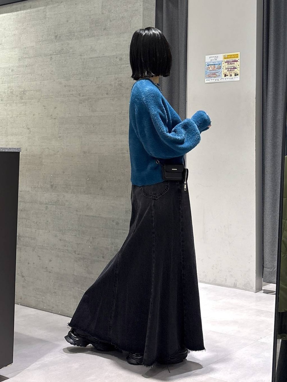 グレー系のタンクトップ、ブルー系のニット/セーター、ブラック系のブーツを着用したレディースの秋コーディネートの6枚目の写真