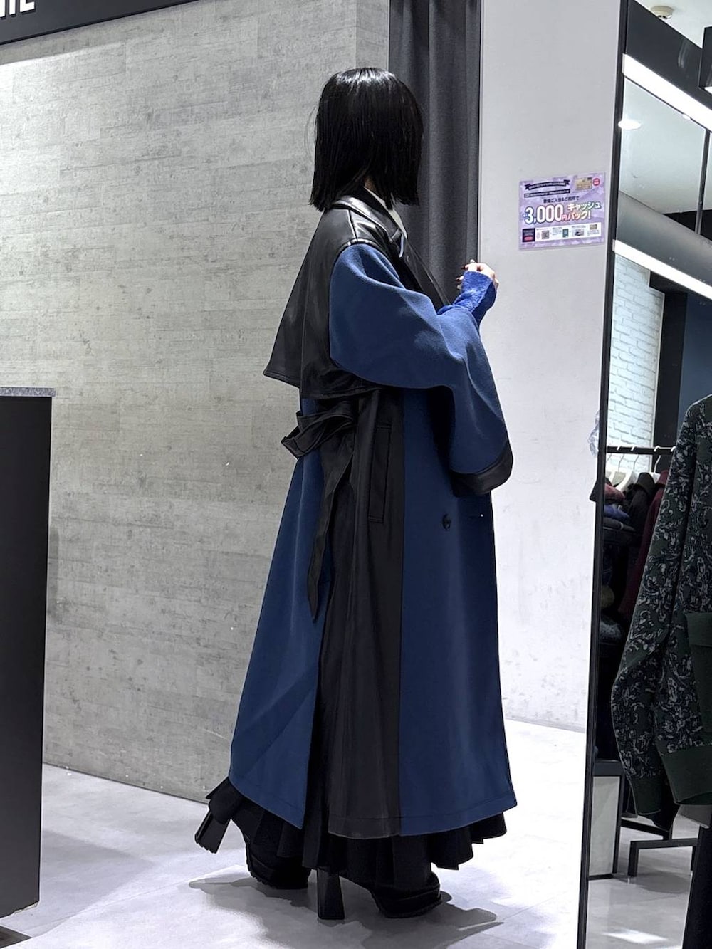 ブラック系のネクタイ、ブルー系のチェスターコート、ブルー系のニット/セーターを着用したレディースの冬コーディネートの6枚目の写真